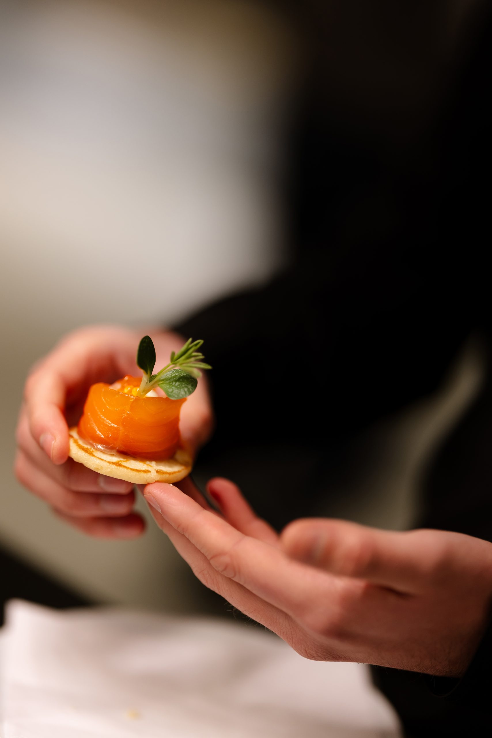 Salmon canapé held in hands