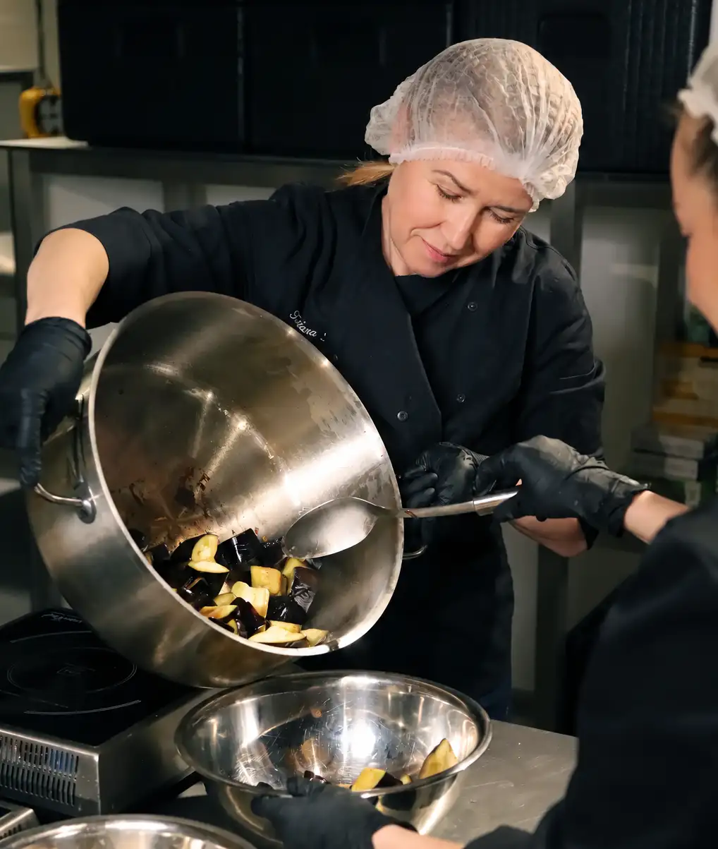 Concordia Catering chef preparing vegetables in a professional kitchen